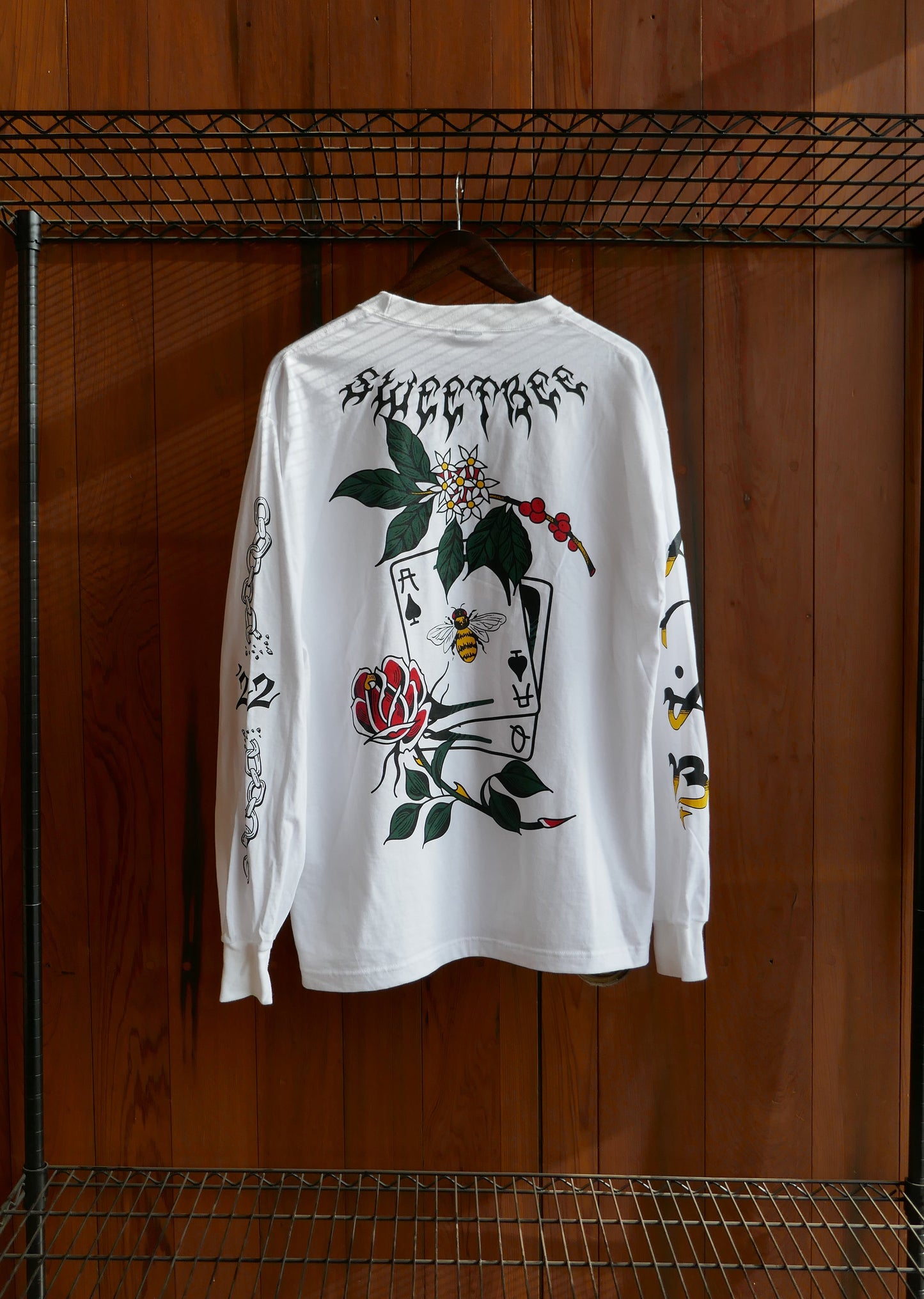 White t-shirt with black and red design on a wooden surface