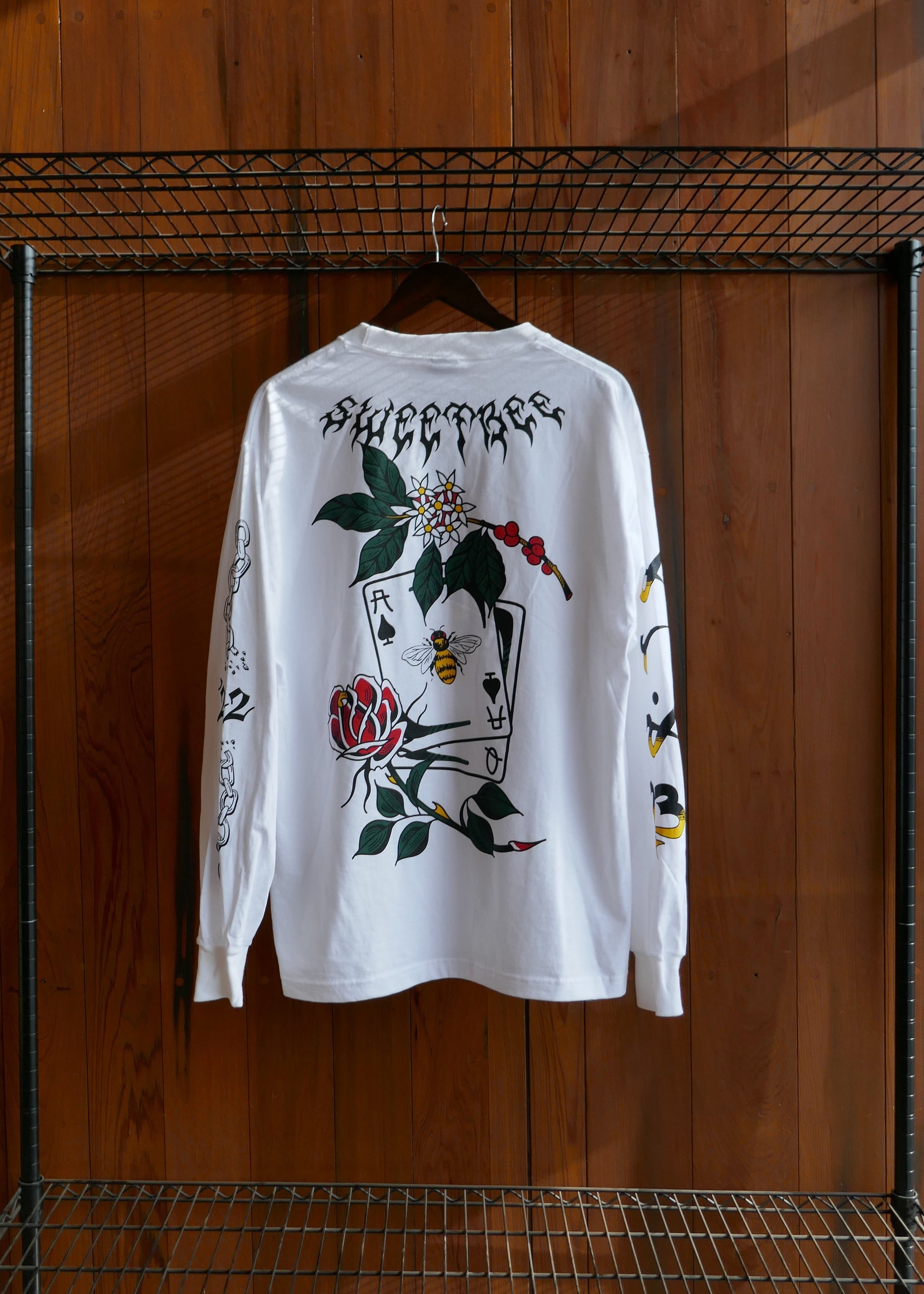 White t-shirt with black and colored graphics on a wooden surface