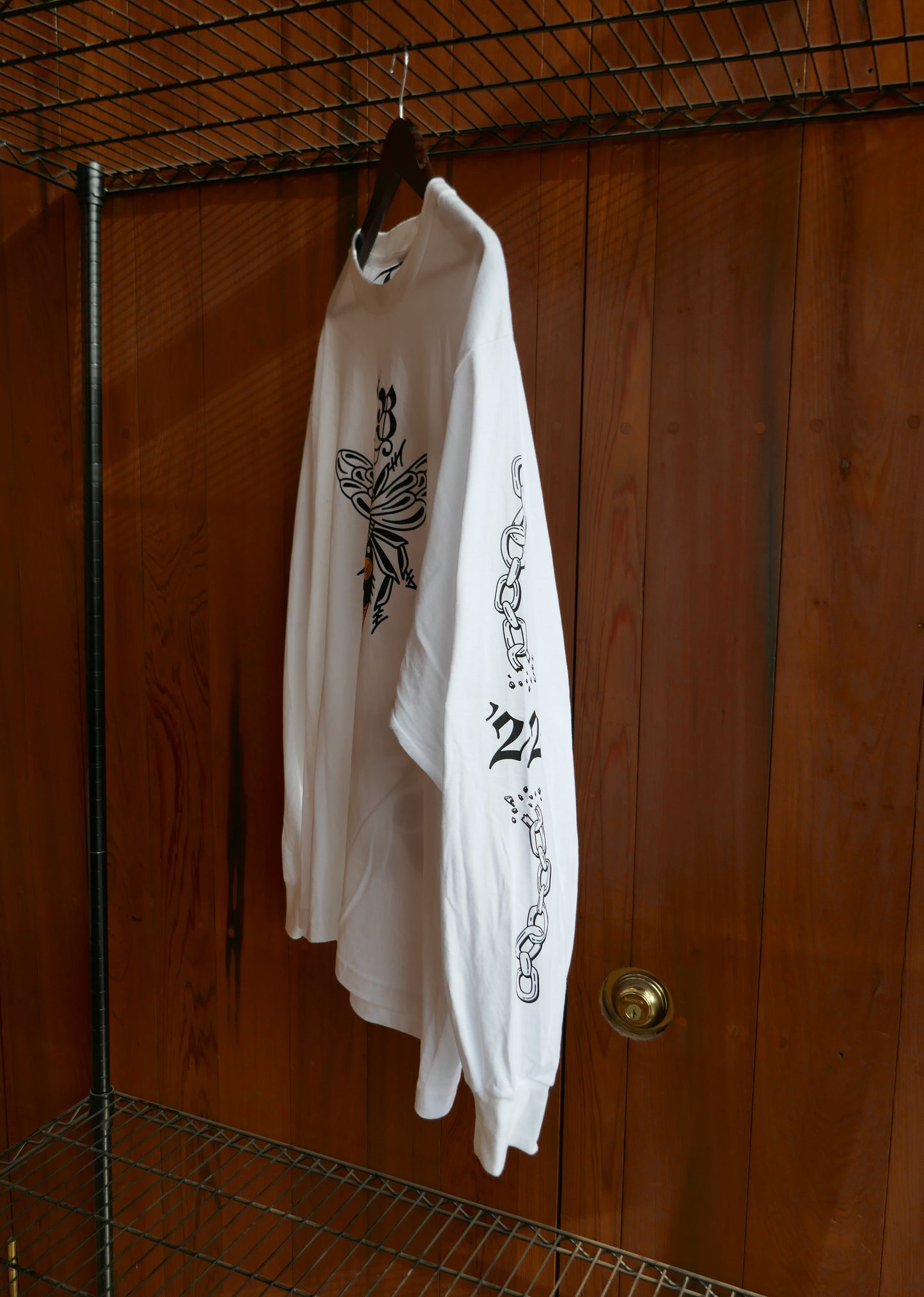White t-shirt with black designs on a wooden surface